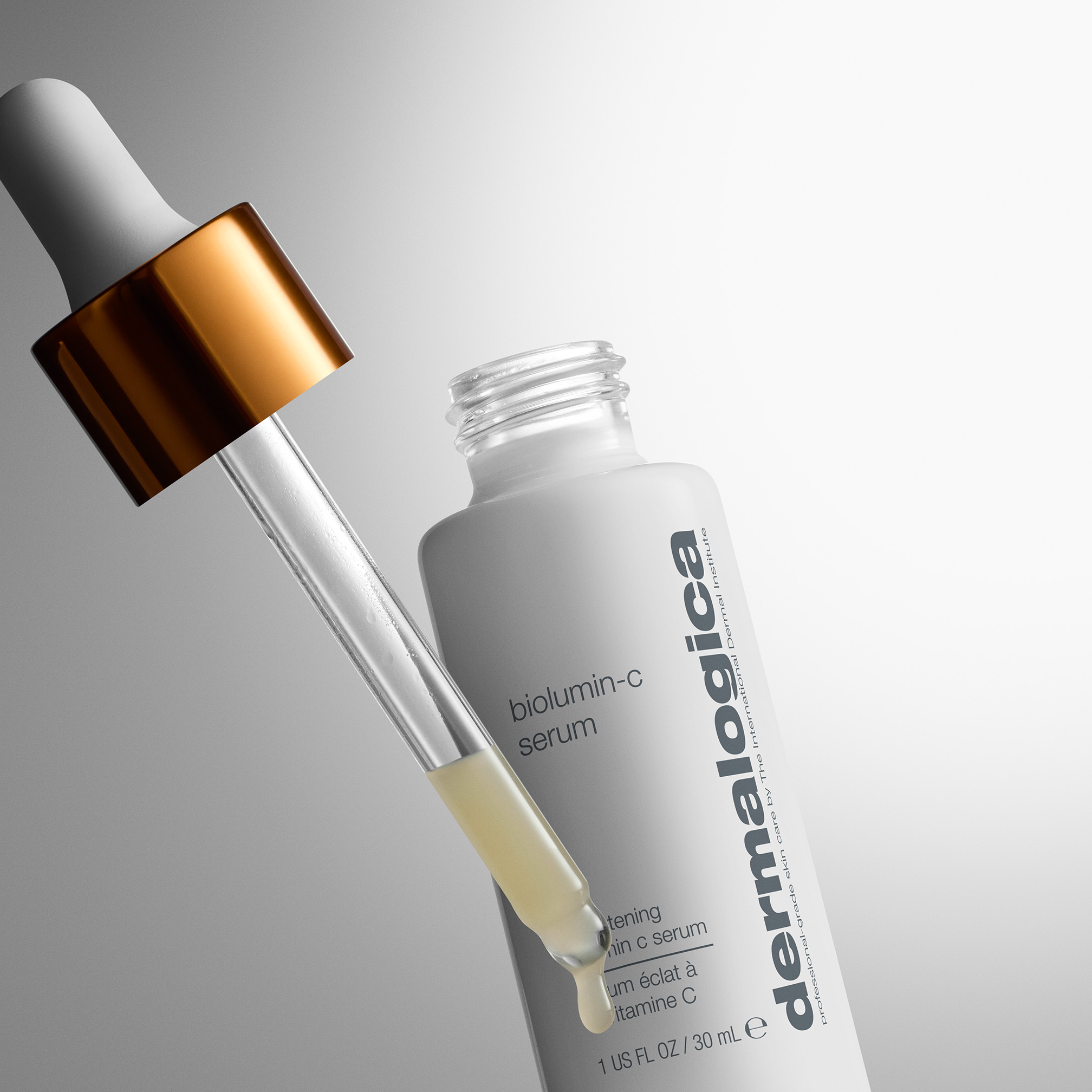 Dermalogica Biolumin-C Serum mit Pipette und Tropfen vor grauem Hintergrund