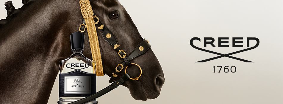 Creed Aventus Eau de Parfum Flakon vor dem Kopf eines edlen, schwarzen Pferdes mit goldenem Zaumzeug. Luxuriöser Nischenduft für Herren.