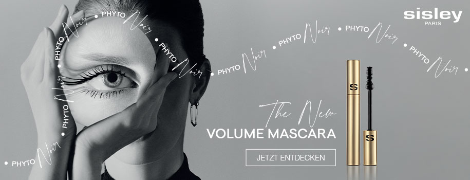 Werbung für Sisley Paris Volume Mascara. Links im Bild ein stilisiertes Schwarz-Weiß-Porträt einer Frau mit dramatisch getuschten Wimpern, die ihr Gesicht mit den Händen rahmt. Rechts daneben ein geöffnetes goldfarbenes Mascara-Produkt. Darüber der Text: 'The New Volume Mascara' und ein Button mit der Aufschrift 'JETZT ENTDECKEN'. Im Hintergrund mehrfach der Schriftzug 'PHYTO NOIR'.